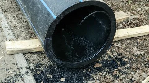 Plastic sewer pipe cut at construction site with shavings scattered on the .. Foto stock