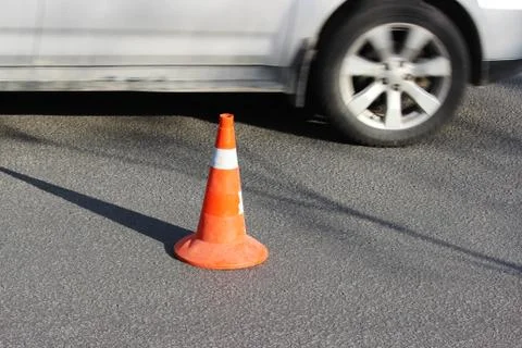 Plastic signaling traffic cone encloses a place in the parking lot for trucks. Stock Photos