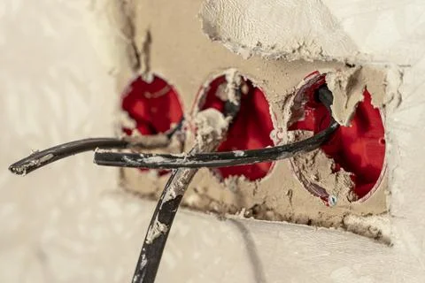 Plastic sockets smeared with mortar and electrical wires for sockets Foto stock