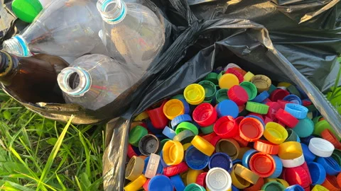 Plastic сollecting for recycling. Plastic caps and plastic bottles recycling Stock Footage 251917360