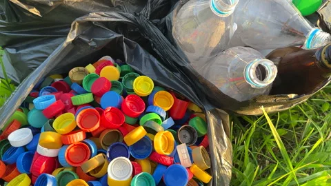 Plastic сollecting for recycling. Plastic caps and plastic bottles recycling Stock Footage 251917618