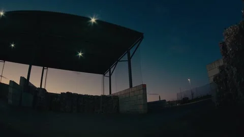 Plastic Sorting Facility Building Exterior with Stacked Waste at Twilight Stock Footage 331166586