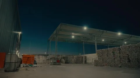Plastic Sorting Facility Building at Night with Large Bales of Recycled Stock Footage 331166673