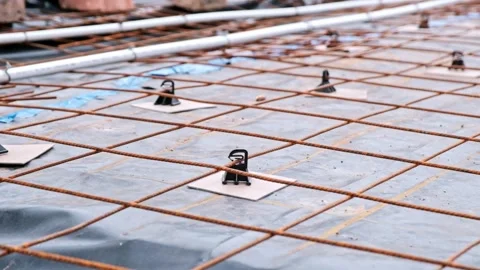 Plastic spacers separate a steel grid from damp proof plastic protection on the Stock Footage 301069416
