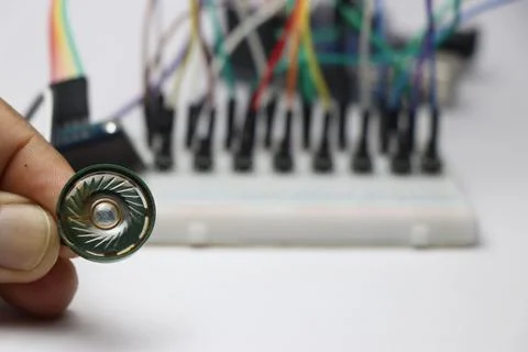 Plastic speaker connected to microcontroller on breadboard background Stock Photos