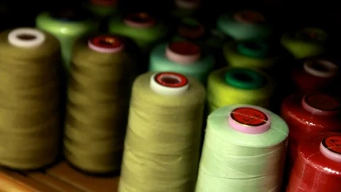 Plastic spools of cotton multicolor thread on sewing machine spindle, close-up Stock-Footage 88381730