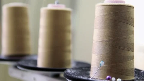 Plastic spools of cotton thread on sewing machine spindle, close-up Stock-Footage 88381697