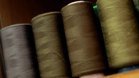 Plastic spools of cotton thread on sewing machine spindle, close-up Stock-Footage 88381727
