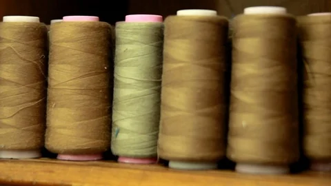 Plastic spools of cotton thread on sewing machine spindle, close-up Vidéo 88381731