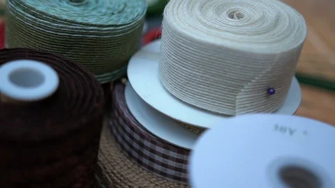 Plastic spools with multicolor fabric ribbon rolls for presents, close-up  Video stock 89240632