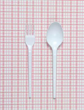 Plastic spoon and fork on a tablecloth. top view. Stockfoto's