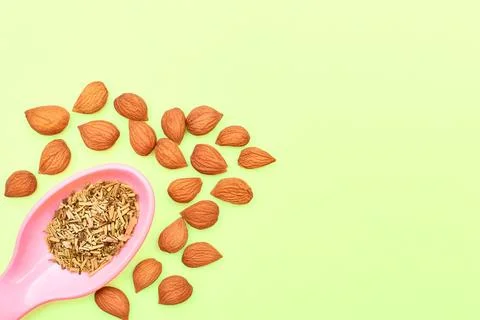 Plastic spoon with spices and apricot kernels for cooking,drinks,baking on lime Stock Photos