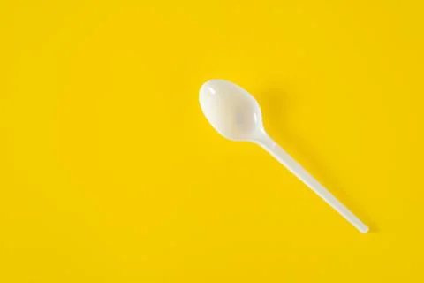 Plastic spoon on yellow background Stock Photos