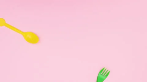 Plastic spoons and forks passing in different directions - Stop motion Vidéo 134837755