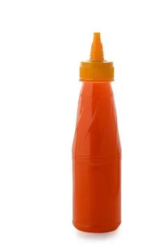 Plastic squeeze bottle filled with orange sauce on a white background Stock Photos