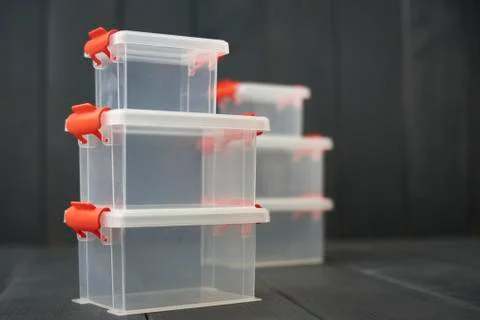 Plastic storage boxes for objects stacked and on wooden floor Stock Photos