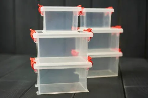 Plastic storage boxes for objects stacked and on wooden floor Stock Photos