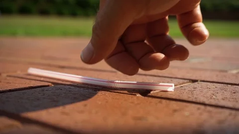 Plastic Straw falls on bricks then picked up SloMo v2 Stock Footage 91748904