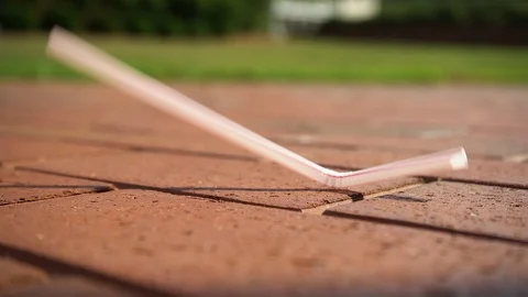 Plastic Straw falls on bricks then picked up SloMo v1 Stock Footage 91748940