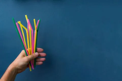 Plastic straws in a hand Stock Photos