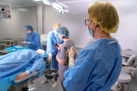 Plastic surgeon and nurses doing eyelid surgery on female patient Stock Photos