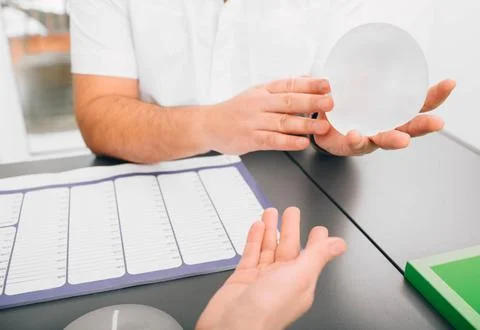 Plastic surgeon demonstrates breast implants to a patient for her new breast. Foto stock