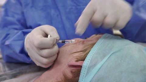Plastic surgeon doing anti-aging injections Stock Footage 75447559