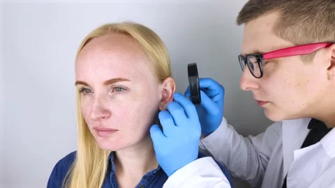 A plastic surgeon examines a patient's auricle. The doctor sees a tubercle on th Stock Footage 139736983