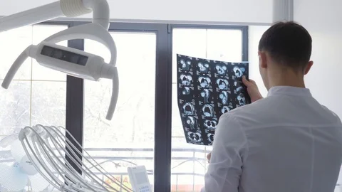 Plastic surgeon examines an x-ray image with implants Stock Footage 124406985