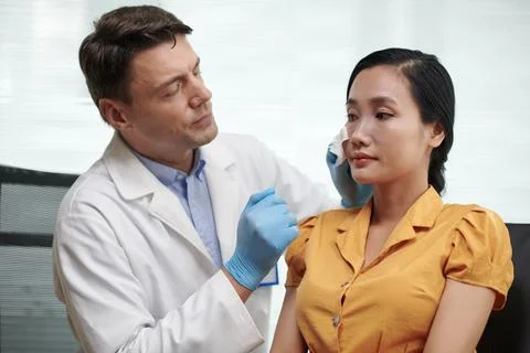 Plastic Surgeon Removing Nose Patch Stock Photos