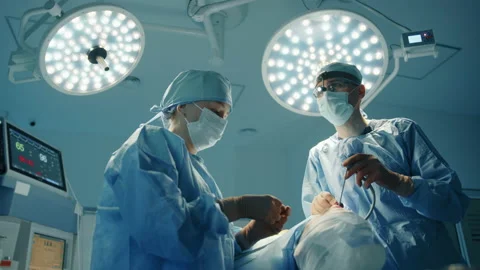 Plastic surgery procedure performed by young male surgeon and nurse Stock Footage 240075519