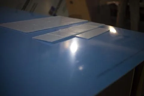 Plastic on table. Transparent material on desktop. Plastic production parts. Stock Photos