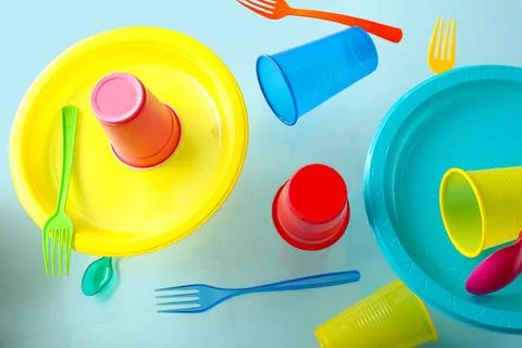 Plastic tableware levitating on blue background Stock Photos
