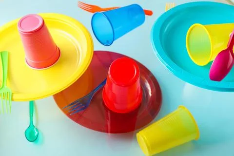 Plastic tableware levitating on blue background Stock Photos