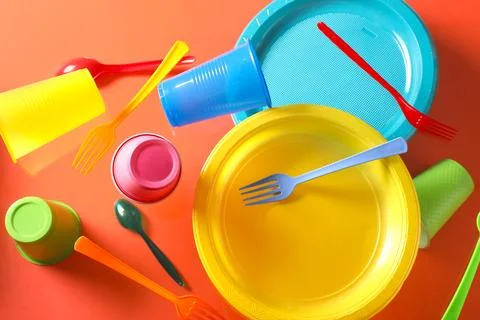 Plastic tableware levitating on red background Stock Photos