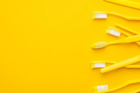 Plastic toothbrushes on yellow background Stock Photos