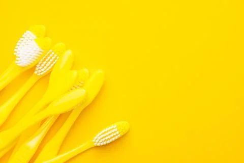 Plastic toothbrushes on yellow background Stock Photos