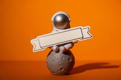 Plastic toy astronaut with paper note template mock up for your text on colorful Stock Photos