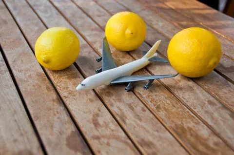 Plastic toy model plane surrounded by yellow lemons 스톡 사진