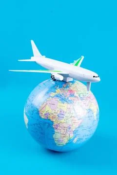 Plastic toy plane on the globe. Flight travel concept. Travel by airplane. Ta Stock Photos