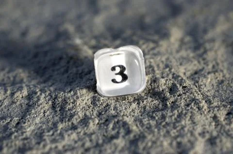 Plastic translucent button number 3 from an old calculator on a concrete back Stock Photos