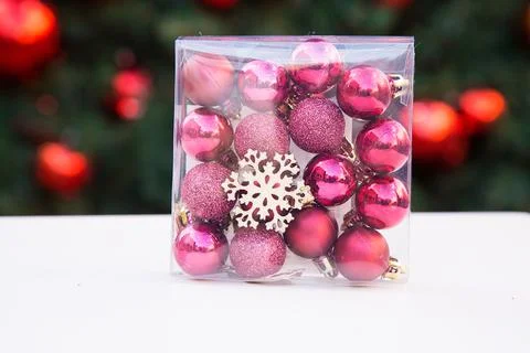 Plastic transparent square box with rose and purple small Christmas balls and Stock Photos