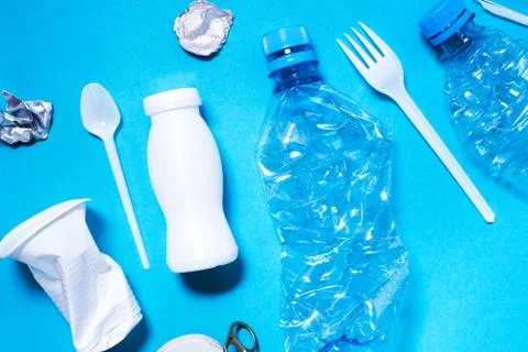 Plastic trash on blue background. Stock Photos