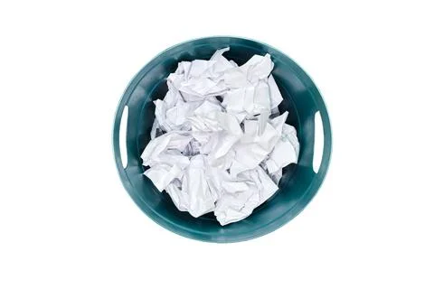 Plastic trash can being filled with crumpled sheets of white paper, isolated  Fotos Stock