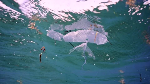Plastic trash floats under surface of water, Slow motion, underwater shot. Stock Footage 252016662