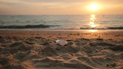 Plastic trash, garbage on the beach. Empty bottle and paper cups at the sea Stock Footage 197540809