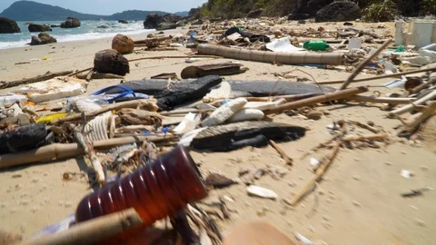 Plastic trash littering the ocean beach. Concept of Ocean Rubbish And Pollution Видео 107046312
