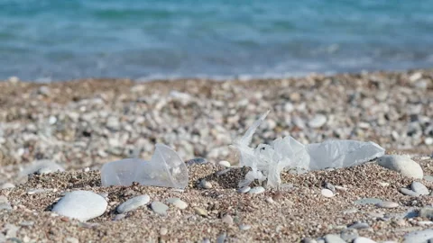 Plastic trash on the sandy beach. Nature pollution concept. Disposable plastic 動画素材 242677358