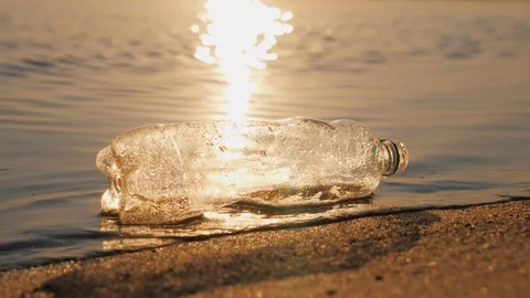 Plastic trash on the seashore. The bottle lies on the edge of the water Stock Footage 119272202