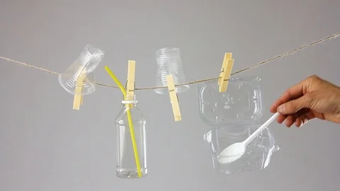 Plastic trash in utensils on clothesline, plastic disposable tableware reuse Видео 112366732